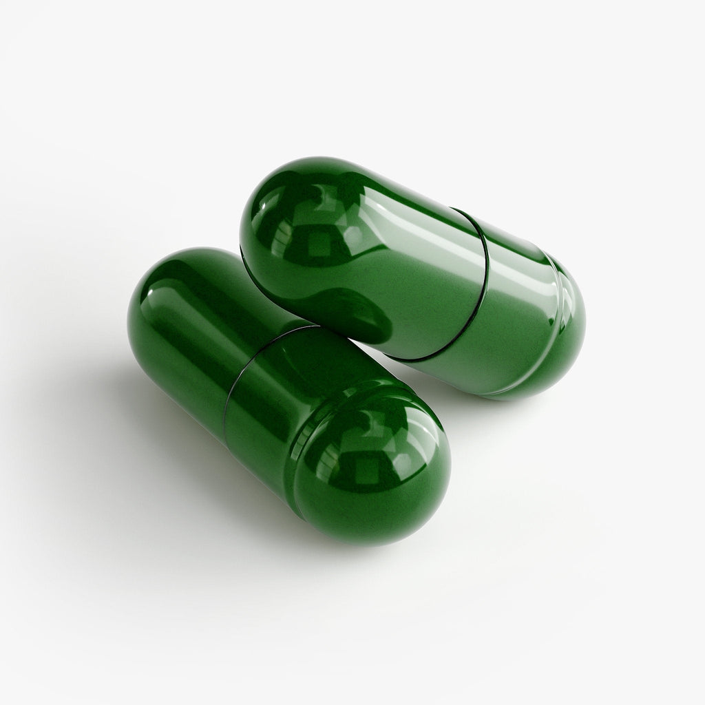 Two dark green gelatin capsules on a white surface