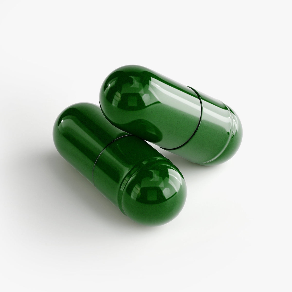 Two dark green gelatin capsules on a white surface